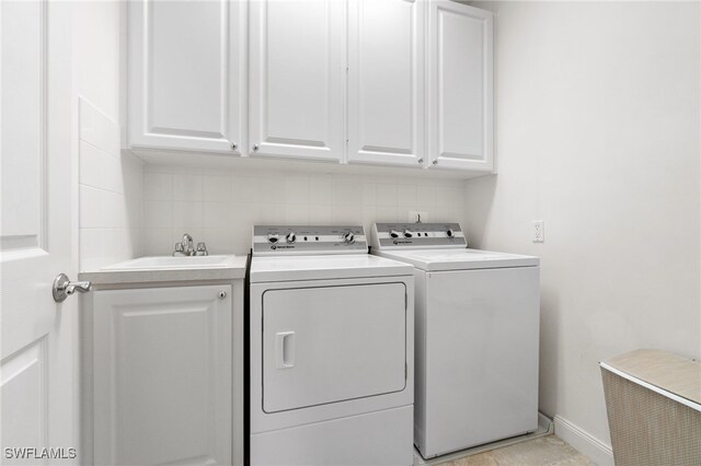 washroom featuring cabinets, washer and dryer, and sink