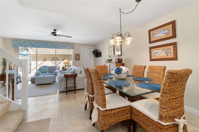 dining area with light tile patterned floors and ceiling fan with notable chandelier