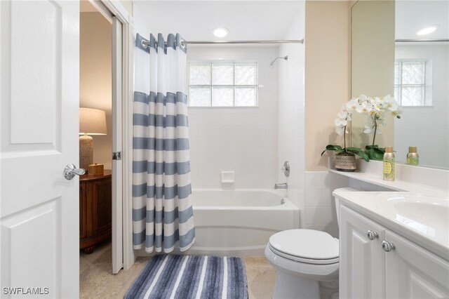 full bathroom featuring tile patterned floors, shower / bath combo with shower curtain, vanity, and toilet