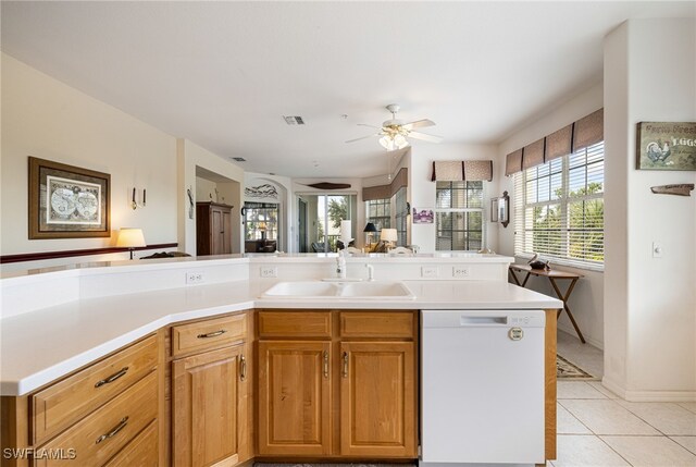 kitchen with light tile patterned floors, white dishwasher, ceiling fan, and sink