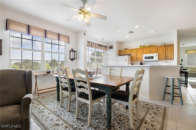 tiled dining space with ceiling fan