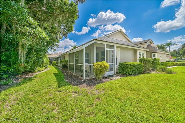 view of side of property featuring a sunroom and a yard