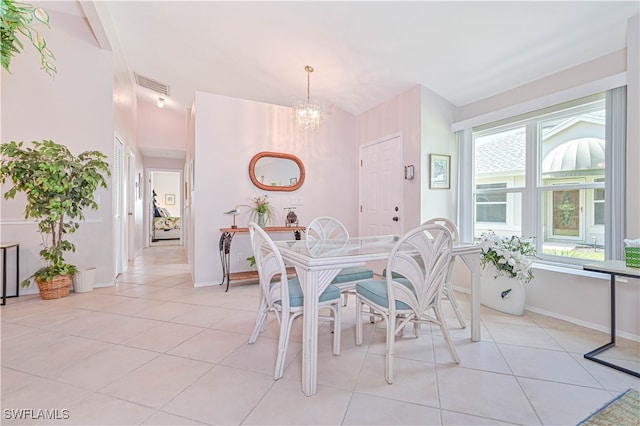 tiled dining space featuring an inviting chandelier