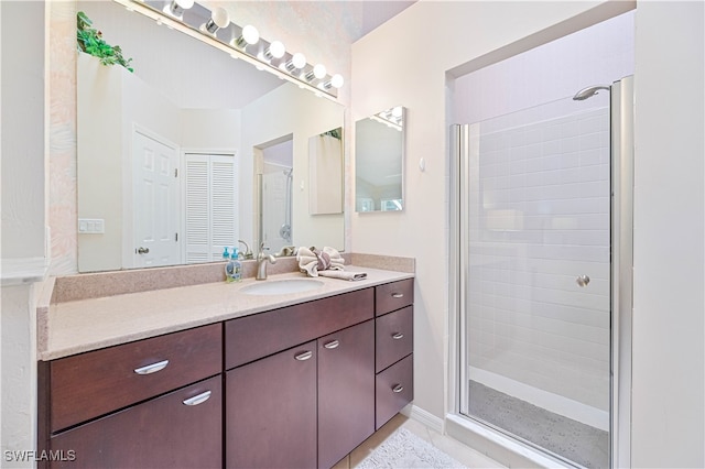 bathroom with a shower with door and vanity