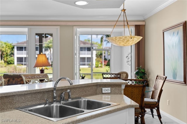 kitchen featuring sink, crown molding, and hanging light fixtures