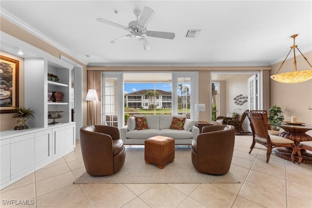 tiled living room with crown molding, built in features, and ceiling fan