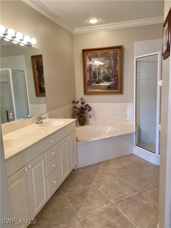 bathroom with vanity, tile patterned floors, ornamental molding, and plus walk in shower