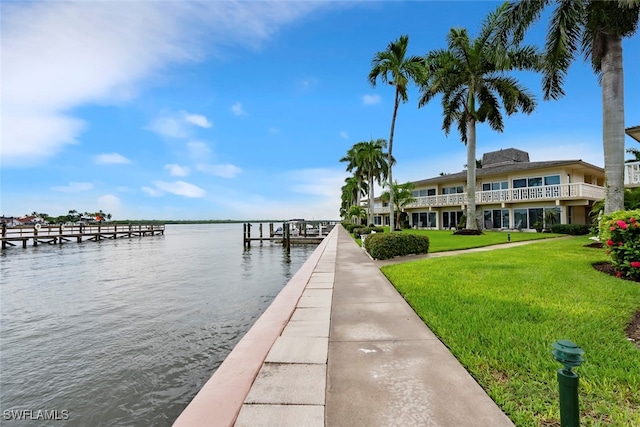 dock area with a water view and a yard