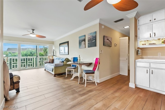 living room featuring ceiling fan, light wood-type flooring, and ornamental molding