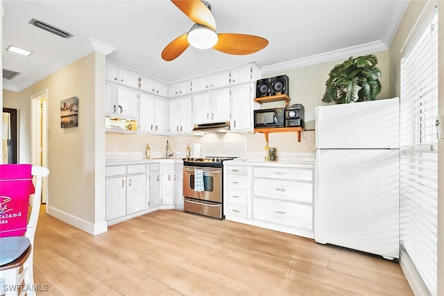 kitchen with light wood-type flooring, stainless steel range oven, white cabinets, and white fridge