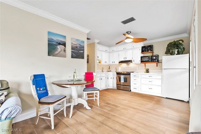 kitchen with stainless steel range, light hardwood / wood-style floors, white fridge, and white cabinetry