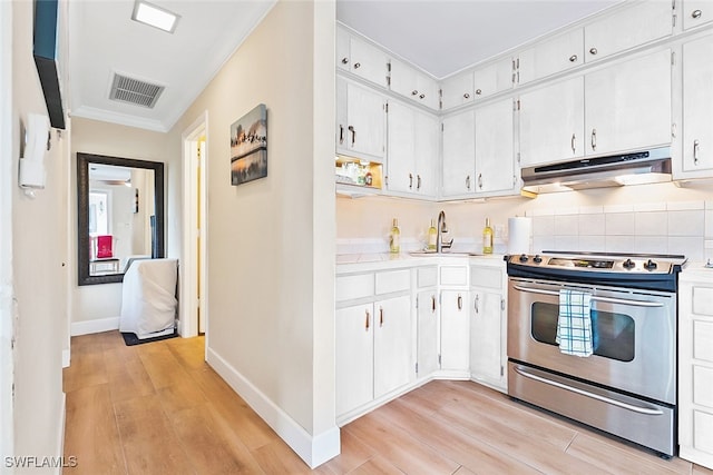 kitchen featuring stainless steel range with electric cooktop, white cabinets, light hardwood / wood-style flooring, and sink