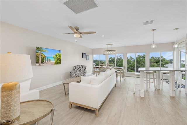 living room featuring light hardwood / wood-style flooring and ceiling fan