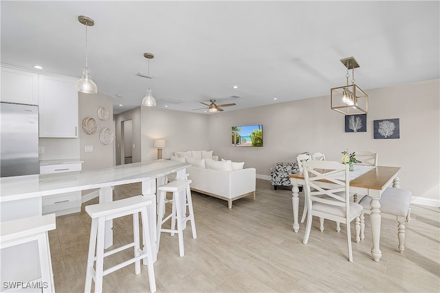 dining area with ceiling fan and light wood-type flooring