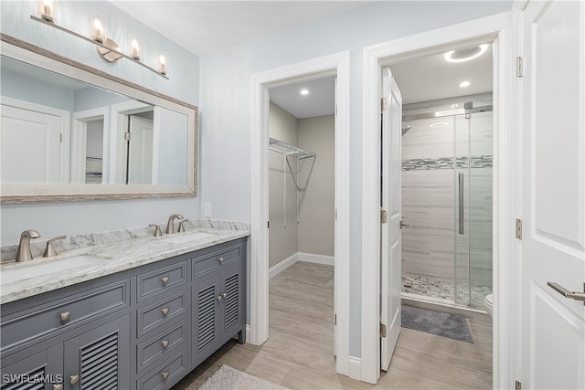 bathroom featuring hardwood / wood-style flooring, walk in shower, vanity, and toilet