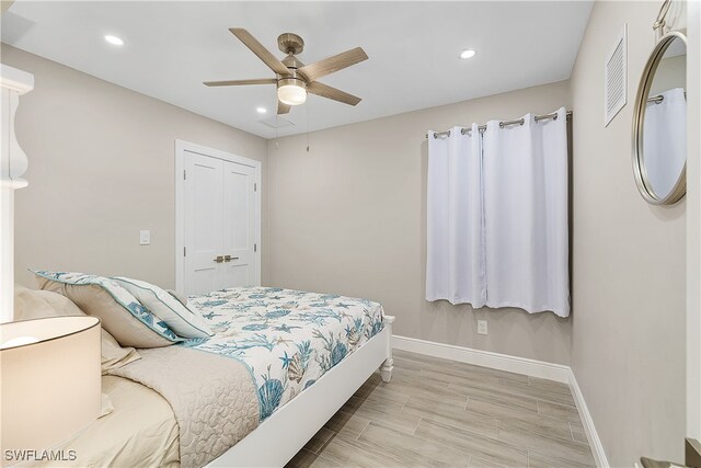 bedroom with a closet, light wood-type flooring, and ceiling fan