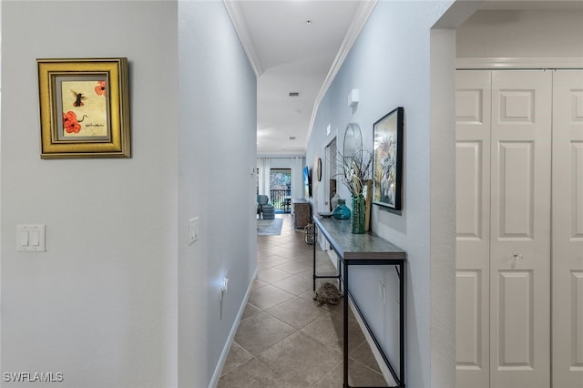 hall with light tile patterned flooring and crown molding