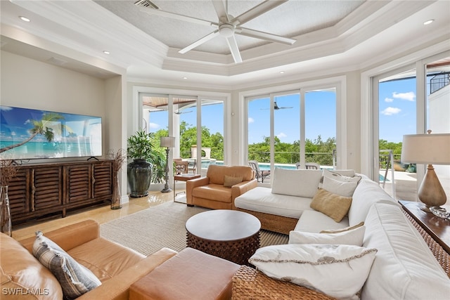 sunroom with ceiling fan, a healthy amount of sunlight, and a tray ceiling