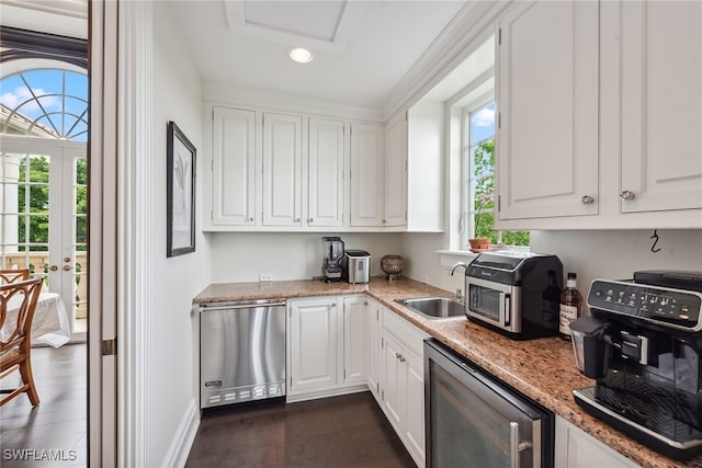 kitchen featuring stainless steel appliances, dark wood-type flooring, white cabinets, sink, and light stone countertops