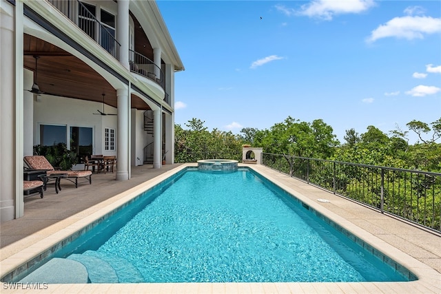 view of swimming pool with ceiling fan, an in ground hot tub, and a patio area