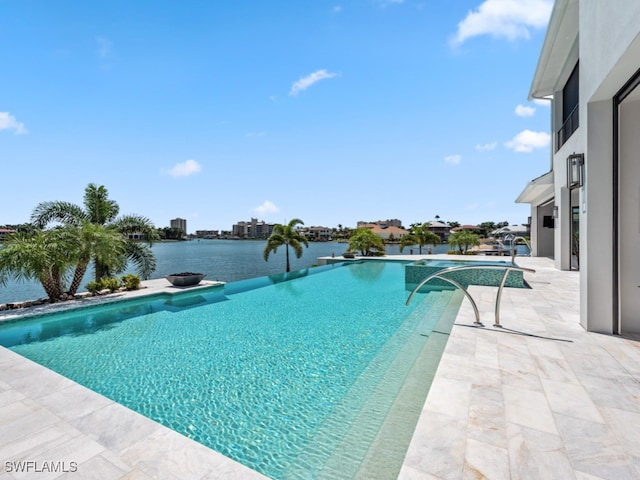 view of pool with a patio and a water view