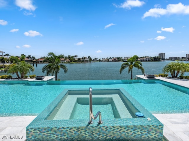 view of swimming pool featuring a water view and an in ground hot tub