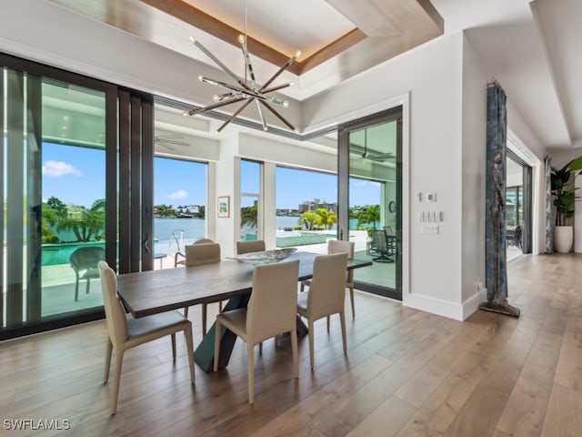 dining space with hardwood / wood-style floors, a water view, and a wealth of natural light