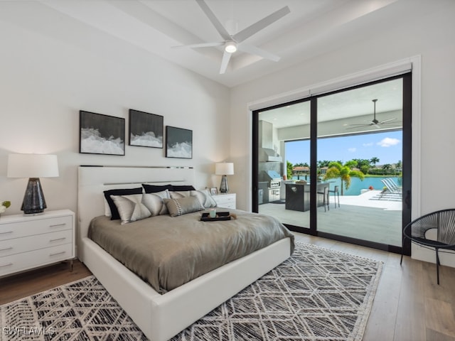 bedroom featuring ceiling fan, wood-type flooring, access to exterior, and a water view