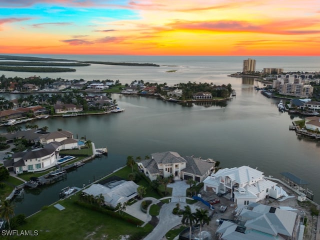 aerial view at dusk featuring a water view