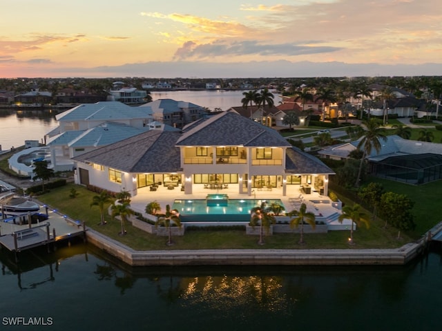 aerial view at dusk featuring a water view