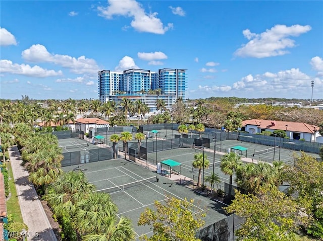 view of sport court featuring fence and a city view