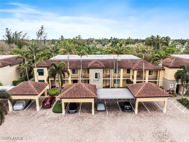 rear view of property with a carport and a balcony