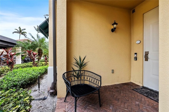 property entrance featuring visible vents and stucco siding