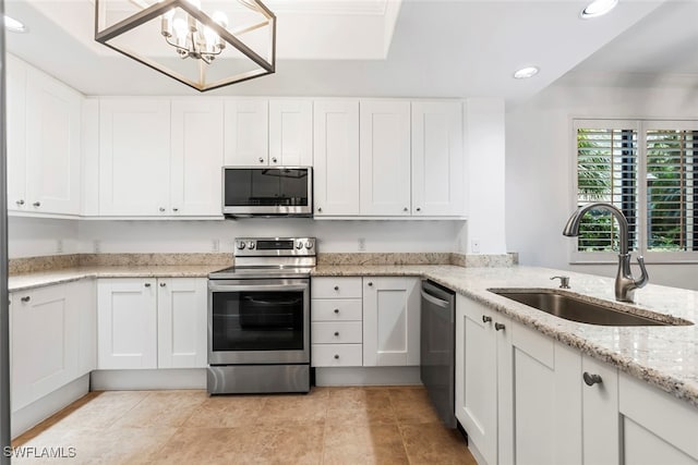 kitchen featuring stainless steel appliances, recessed lighting, ornamental molding, white cabinetry, and a sink