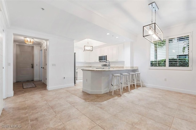 kitchen with baseboards, a peninsula, stainless steel appliances, light countertops, and white cabinetry