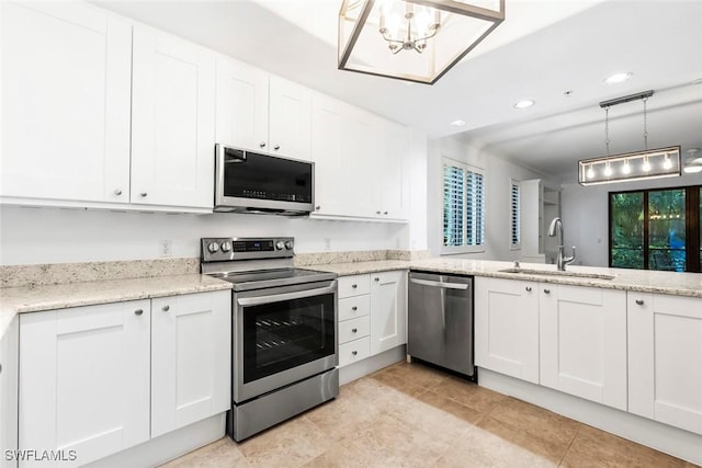 kitchen featuring stainless steel appliances, a sink, white cabinetry, and light stone countertops