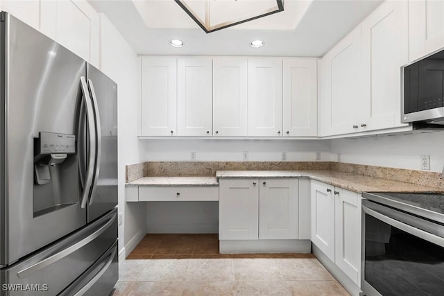 kitchen with light tile patterned floors, light stone countertops, stainless steel appliances, white cabinetry, and recessed lighting