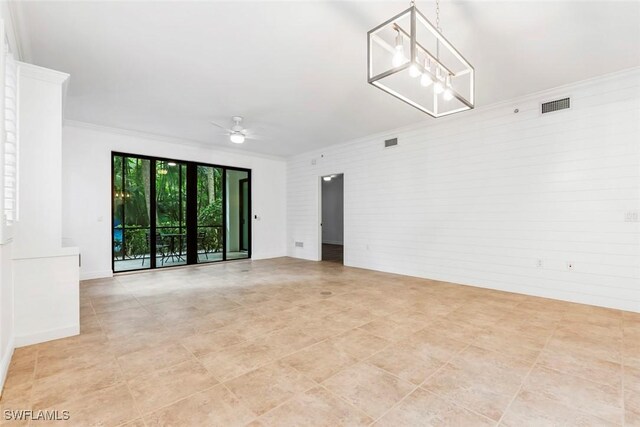 empty room featuring ornamental molding and ceiling fan with notable chandelier