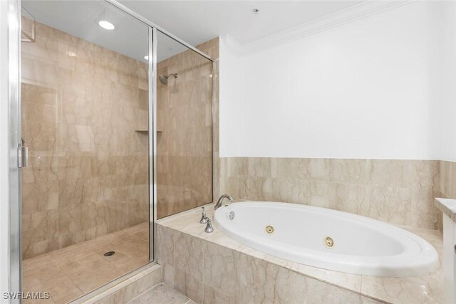 full bath with a tub with jets, ornamental molding, and a shower stall