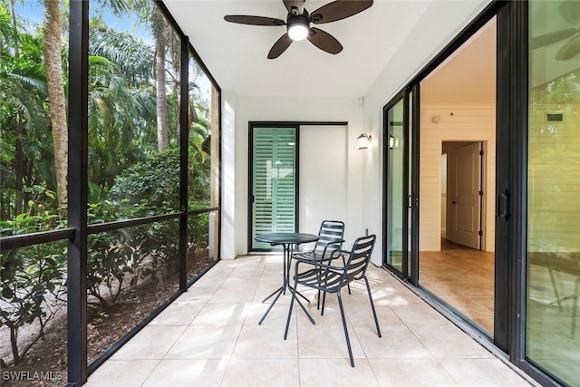 unfurnished sunroom with ceiling fan