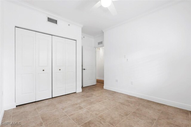 unfurnished bedroom with a closet, crown molding, light tile patterned floors, and ceiling fan