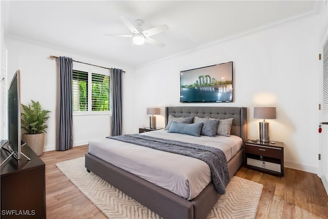 bedroom with ornamental molding, light wood-type flooring, ceiling fan, and baseboards