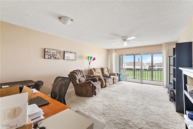 home office with ceiling fan, carpet flooring, and a textured ceiling