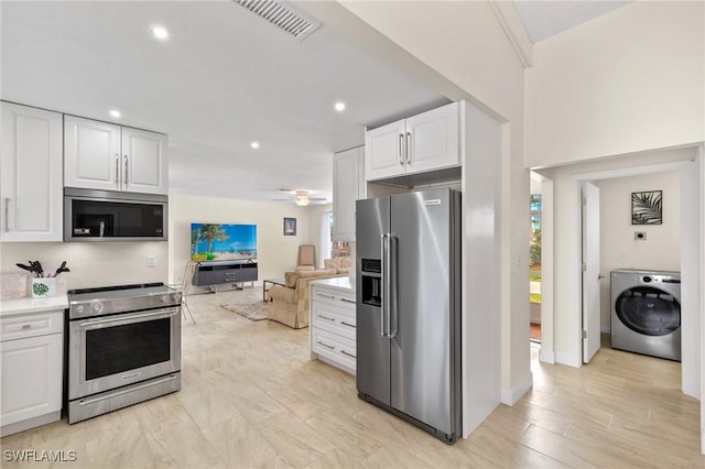 kitchen featuring white cabinetry, ceiling fan, stainless steel appliances, light hardwood / wood-style flooring, and washer / clothes dryer