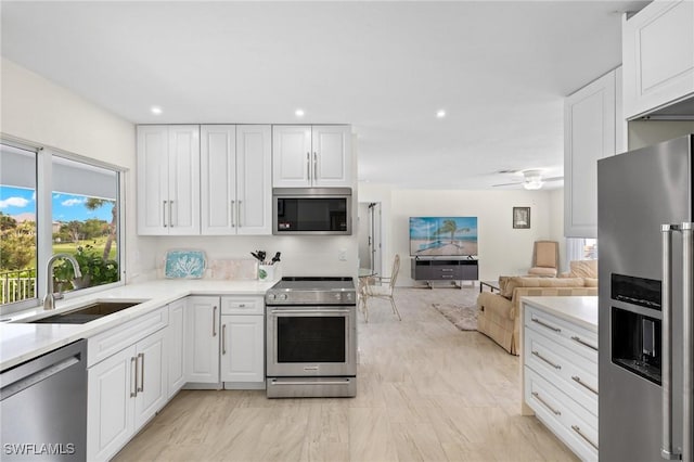 kitchen with ceiling fan, sink, white cabinets, and appliances with stainless steel finishes