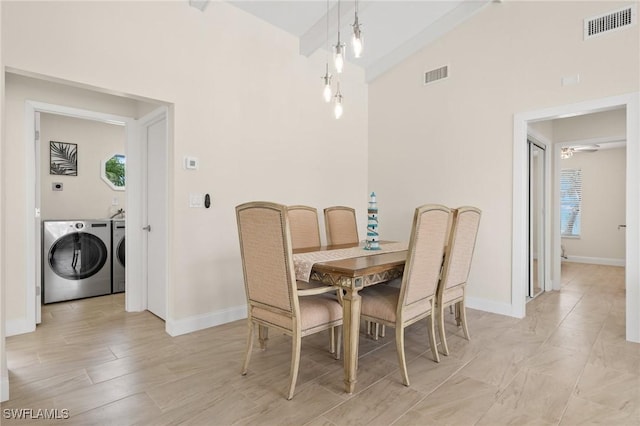 dining area with washing machine and dryer and high vaulted ceiling