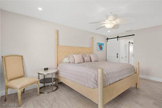 bedroom featuring a barn door and ceiling fan