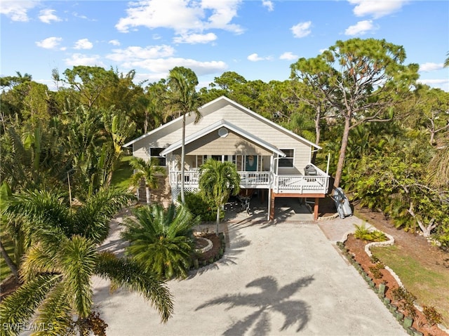 10610 Habitat Trl, Bokeelia, FL 33922 - raised beach house featuring concrete driveway, a porch, and stairway