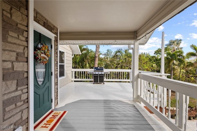 wooden deck with a grill and a porch