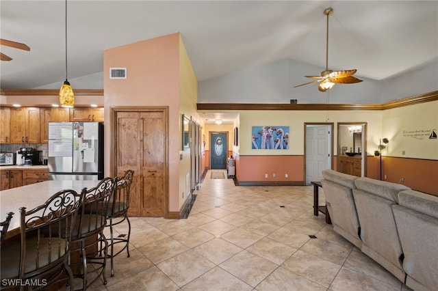 kitchen featuring stainless steel fridge, high vaulted ceiling, ceiling fan, and pendant lighting